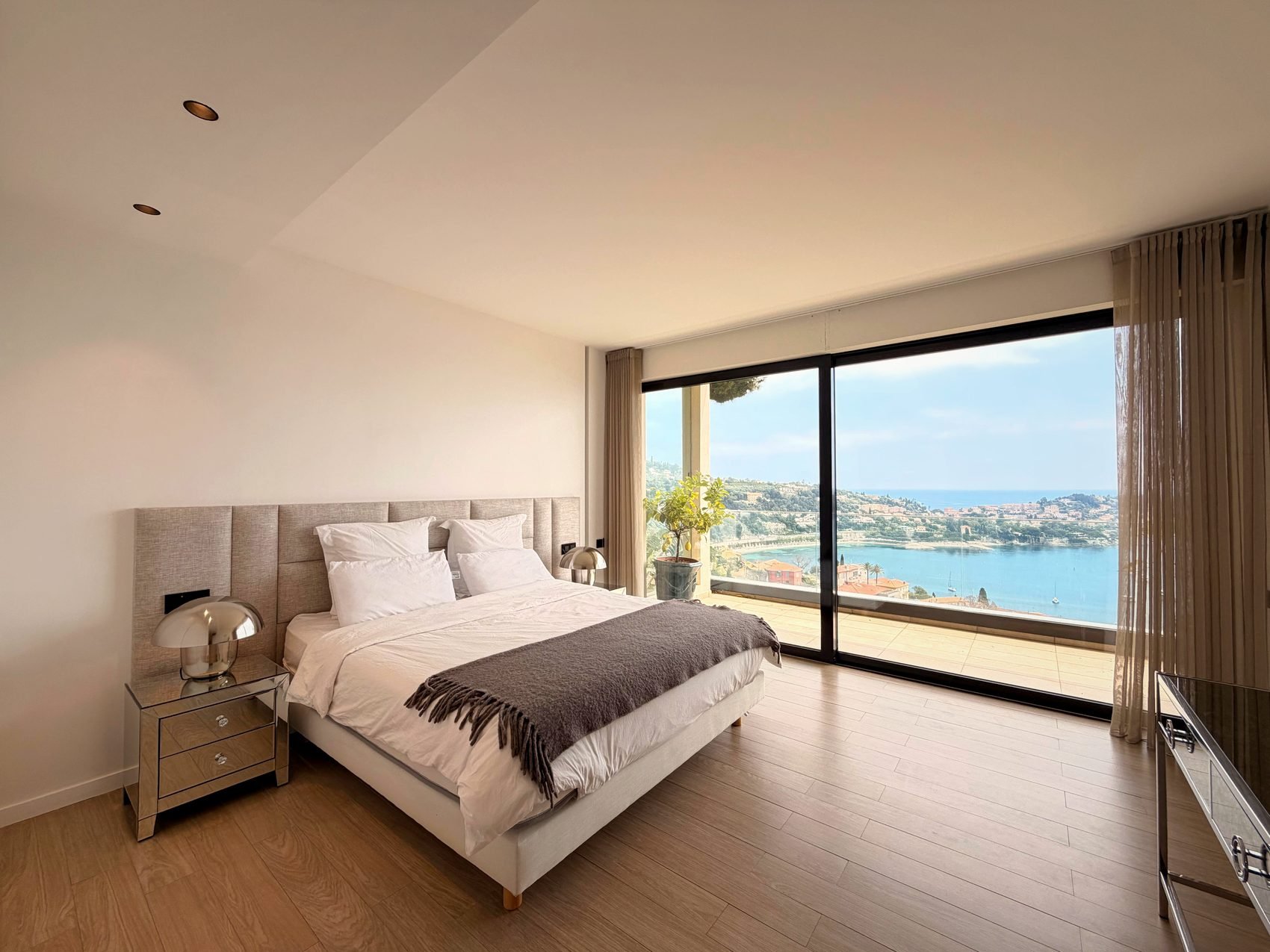 Principal double bedroom with a wall of glass framing the sea